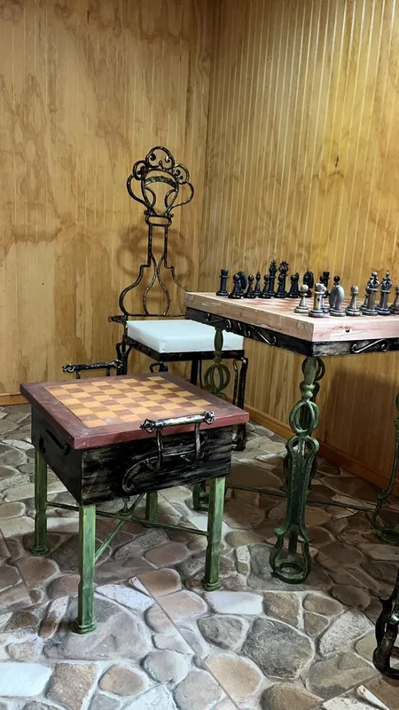 An iron chess table with pieces and chairs.